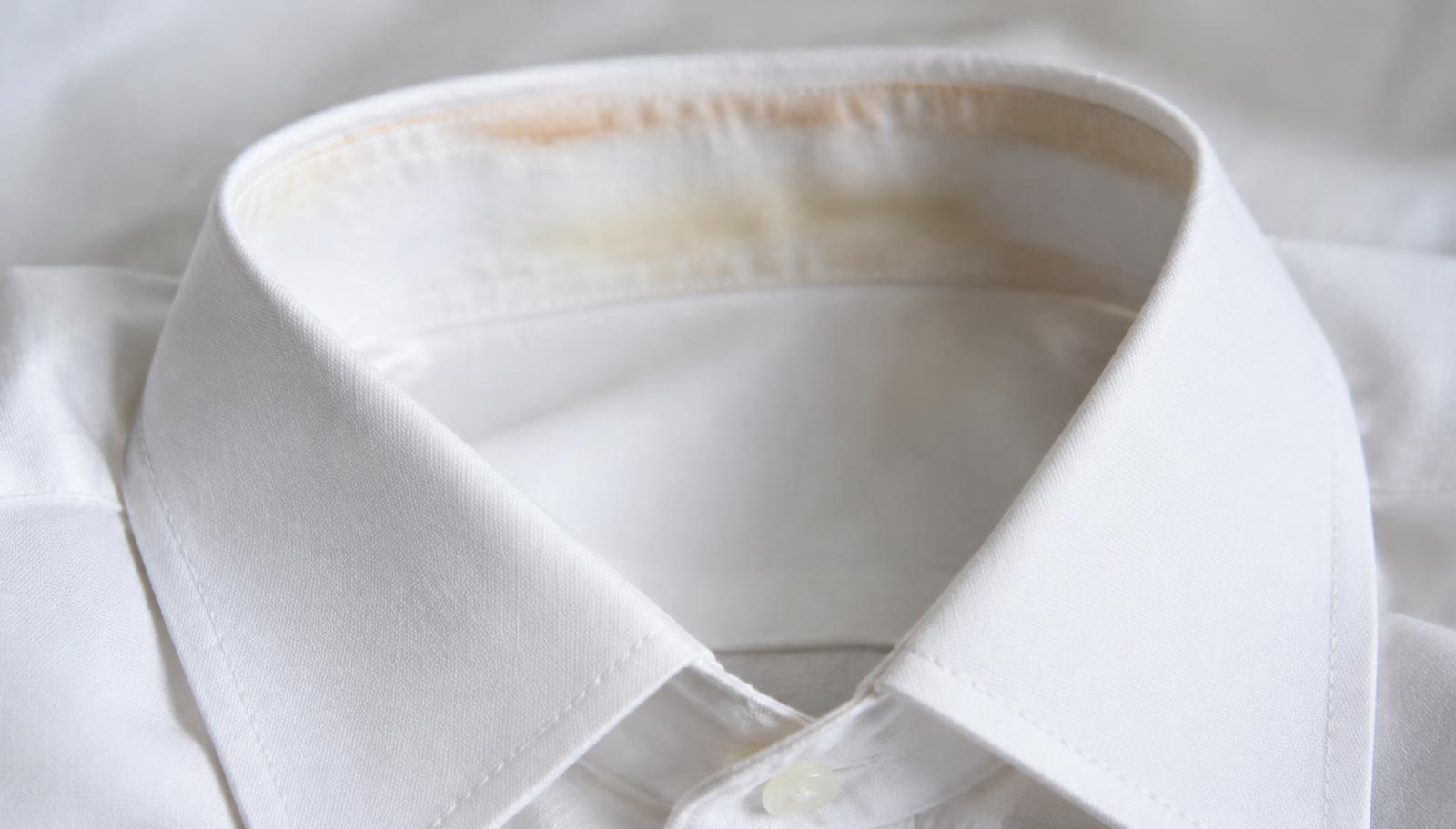 Close-up of the inside of a white shirt collar showing a faint yellow-beige ring of build-up along the collar band